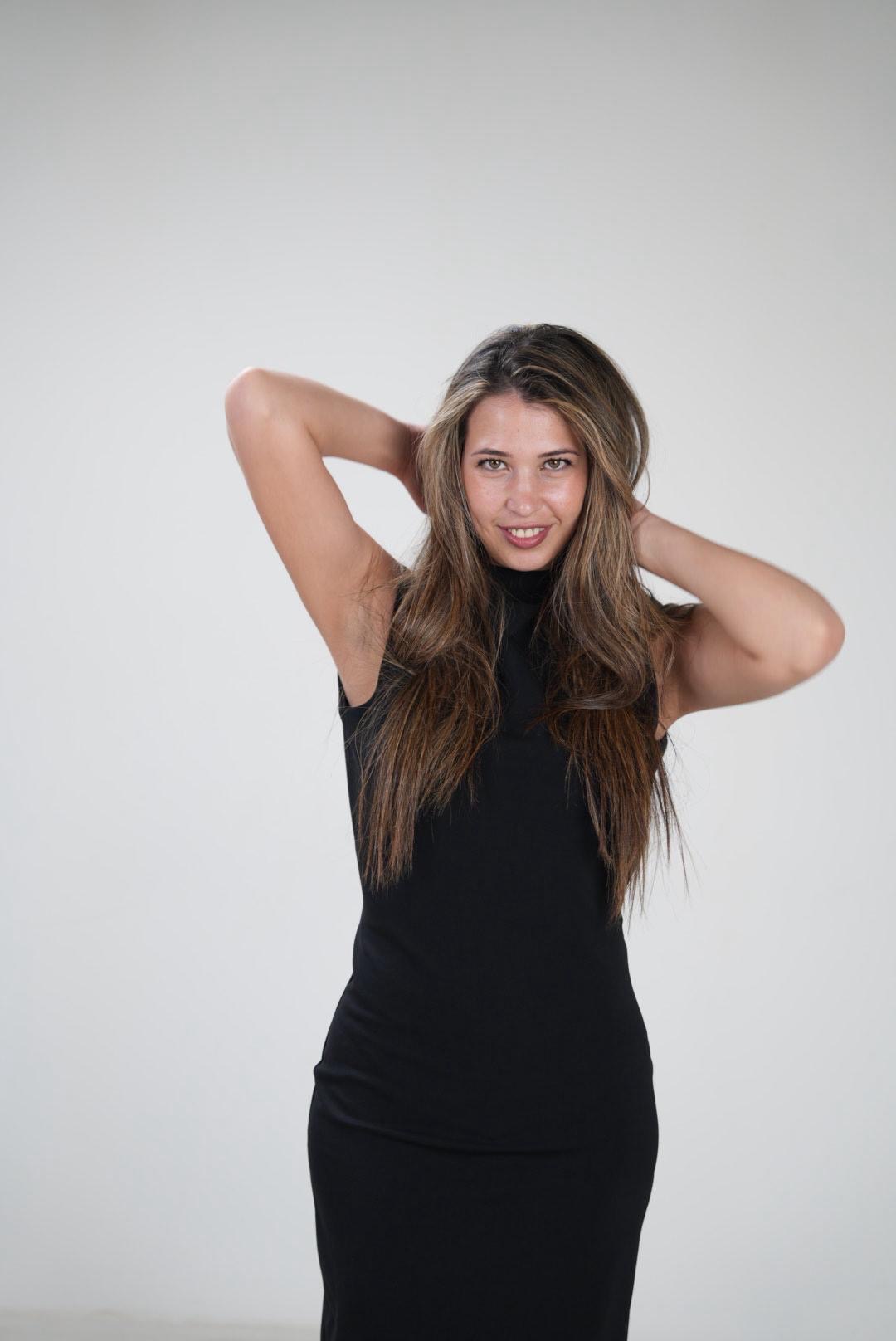 Blanca Izquierdo con vestido negro y las manos en el pelo